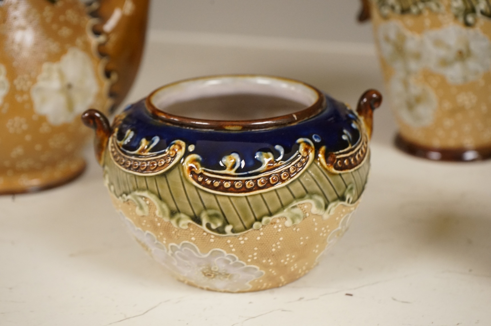 A small collection of Doulton Lambeth stoneware comprising, tea and coffee pots, two jugs and sugar bowl, largest 21cm high